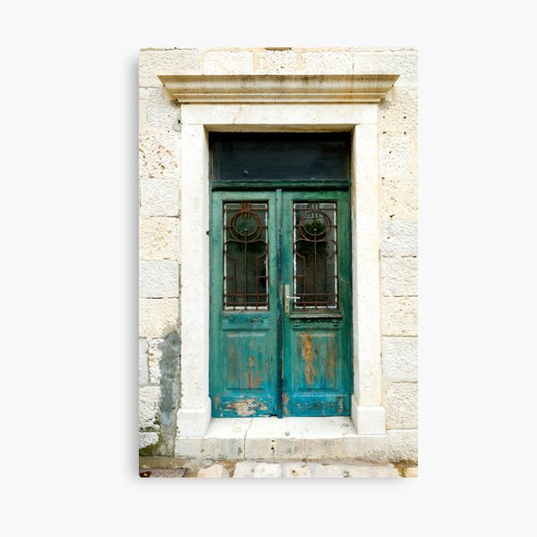Old green door with antique art-nouveau wrought iron. Canvas Print