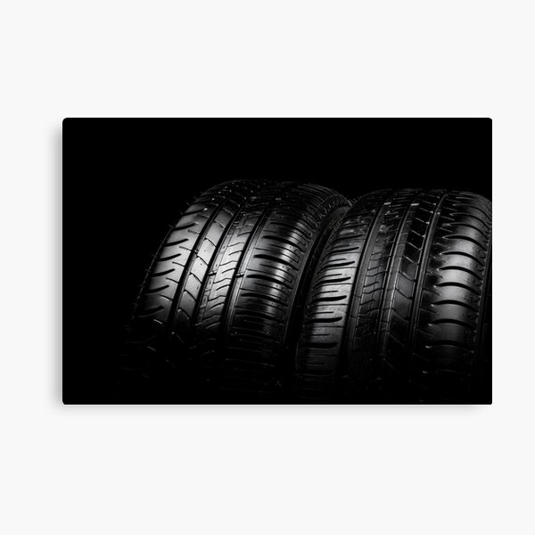 Close up view of a car tyres isolated on a black background Canvas Print