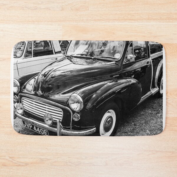 Item preview, A black and white image of the front of a black 1967 Morris Minor Traveller on display at a car show designed and sold by Graham Cornall.