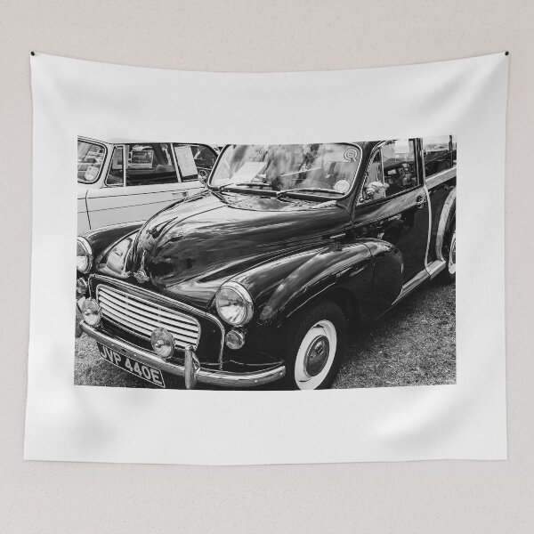 Item preview, A black and white image of the front of a black 1967 Morris Minor Traveller on display at a car show designed and sold by Graham Cornall.