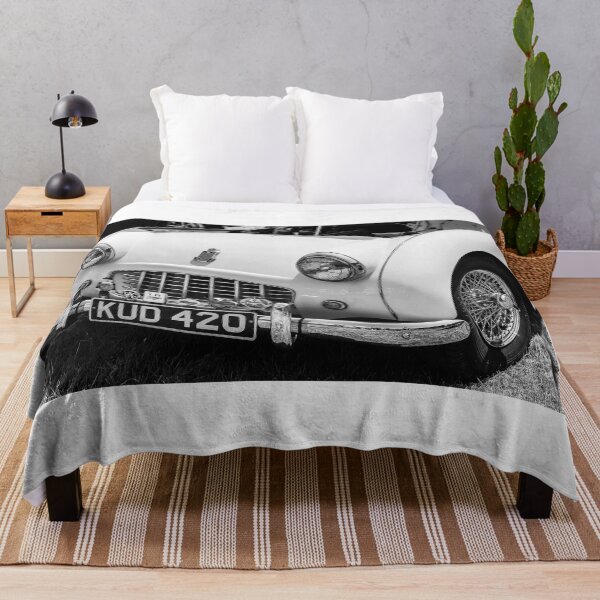Item preview, A black and white image of the front of a white 1950s Triumph TR3 on display at a car show designed and sold by Graham Cornall.