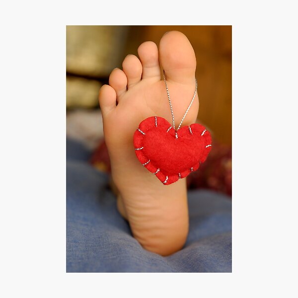 Valentine heart hanging on girl's barefeet Photographic Print