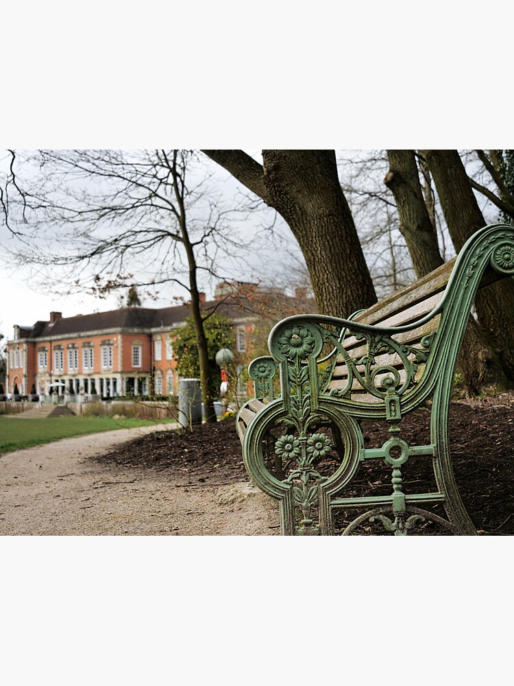 A bench in the park with a background of South Hill Park Arts Centre, Bracknell, England, UK by santoshputhran