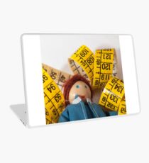 Doll resting on measuring tape Laptop Skin