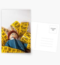 Doll resting on measuring tape Postcards