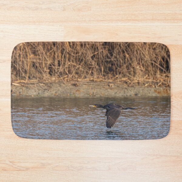 Item preview, The great cormorant flies at water level over a river designed and sold by brambillasimone.