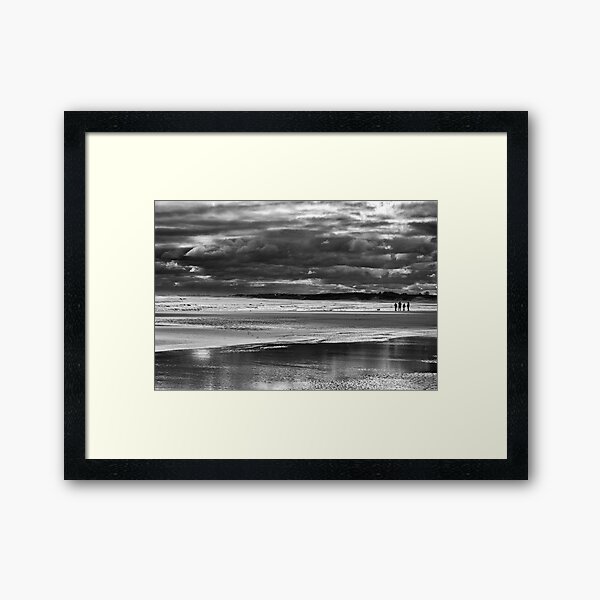 Family on storm beach Framed Art Print
