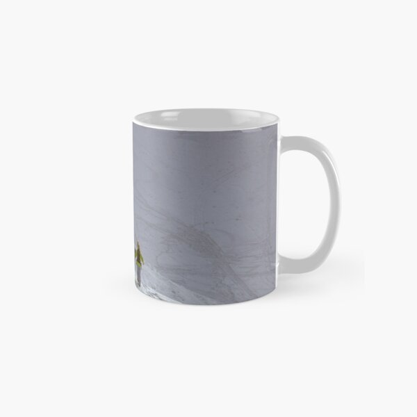 Skier walking uphill on snow mountain Classic Mug