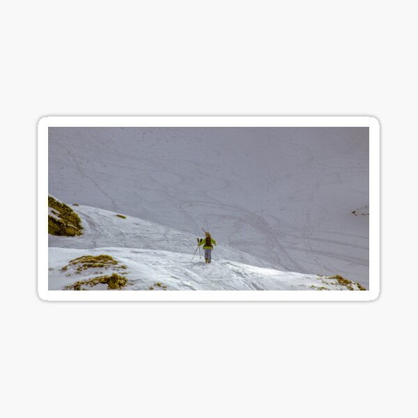Skier walking uphill on snow mountain Sticker