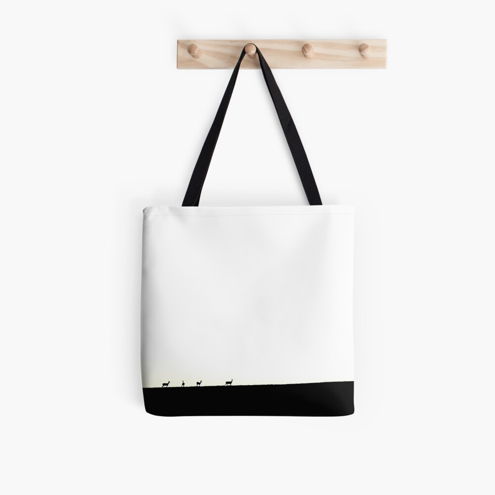 Deer figures, pixilated, silhouette, seen and photographed on a hill, at sunset, in the distance, games of shadows, lights and colors Tote Bag