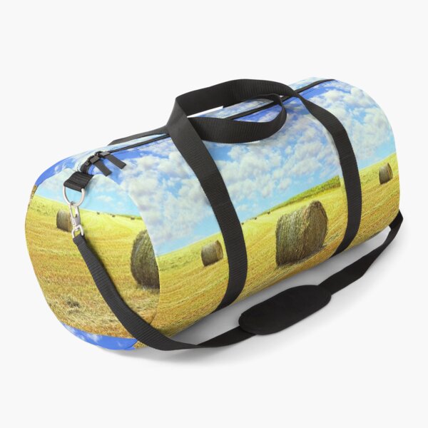 Item preview, Golden stubble field and hay bales against blue cloudy sky. designed and sold by IaroslavB.