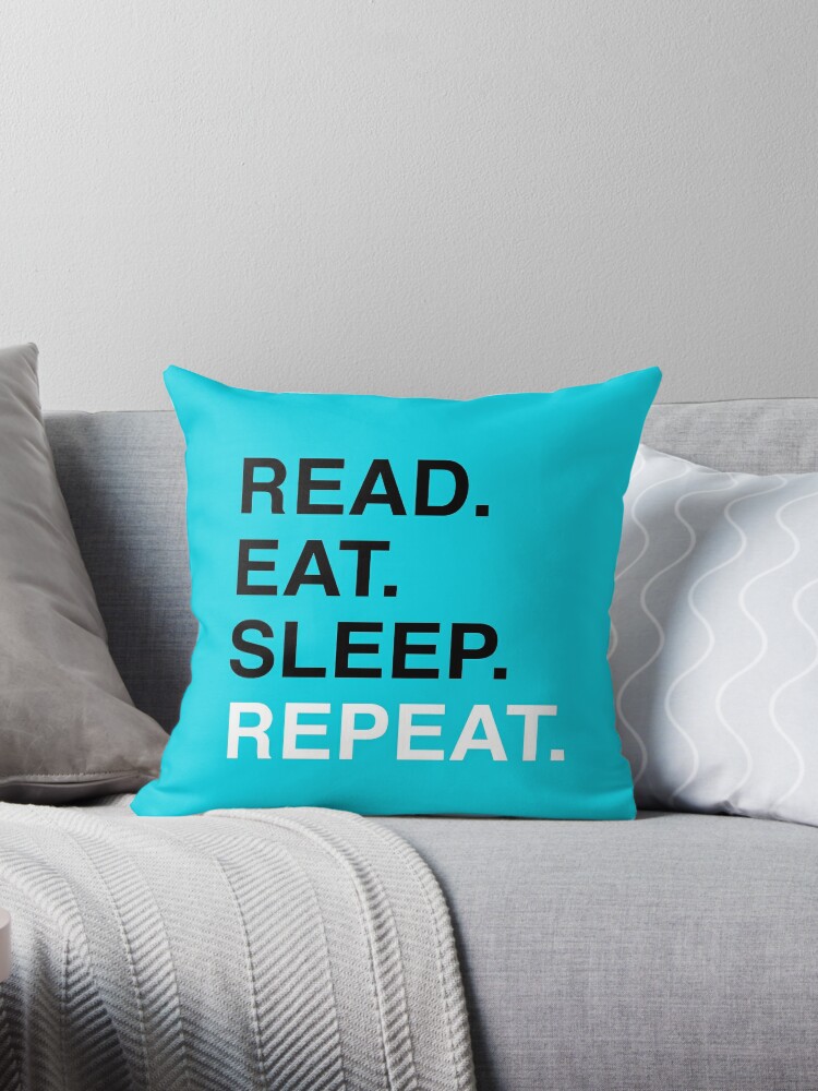 Cojín con la obra Leer. Comer. Dormir. Repetir. (Azul), diseñada y vendida por Kitmagic