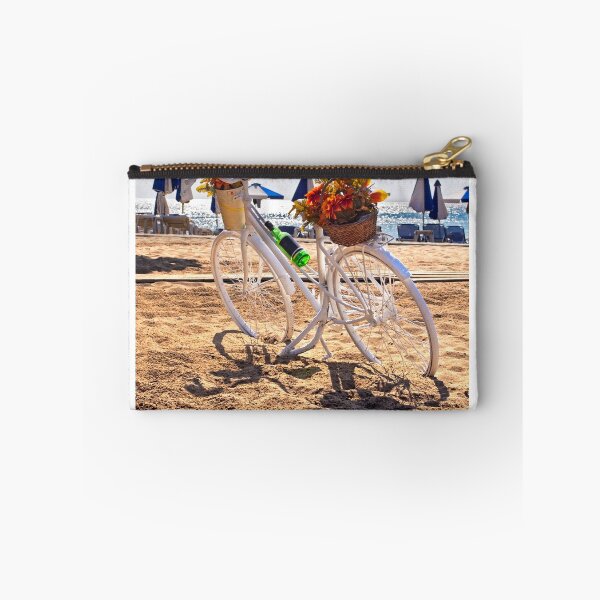 Item preview, White bicycle decorated with baskets of flowers parked on golden beach with sea and umbrellas background designed and sold by Flavio Vieri.