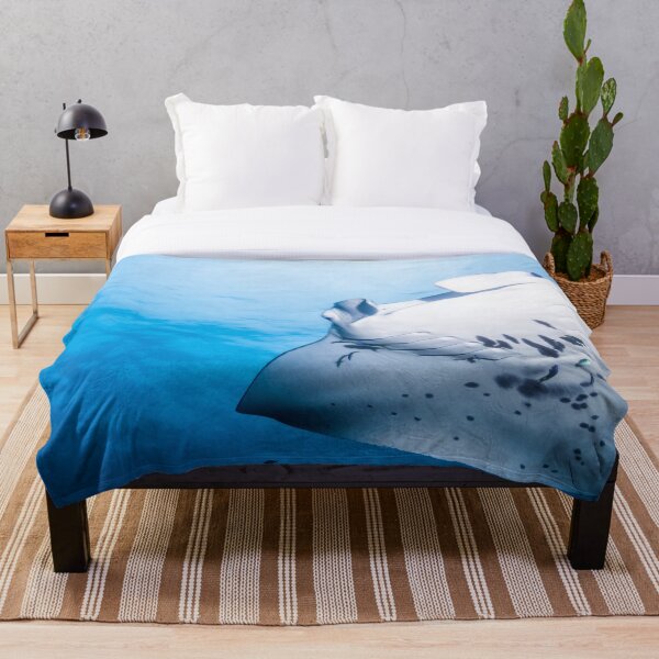 Cute Manta ray swimming in the blue ocean Throw Blanket
