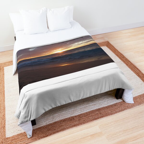 Setting sun illuminates waves Comforter