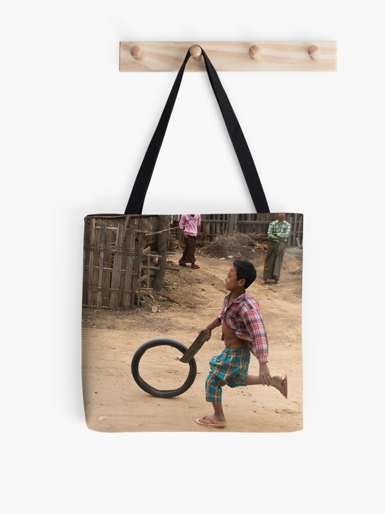 Thumbnail 1 of 2, Tote Bag, A Child Playing With A Wheel in Myanmar designed and sold by missatgerebut.