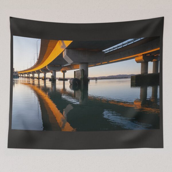 Item preview, Morning sun strikes side Tauranga Harbour Bridge in golden hue reflected leading lines into calm water below  designed and sold by Brian Scantlebury.