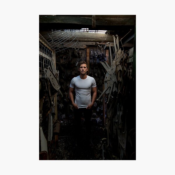 Fit young man standing in a dark industrial workshop Photographic Print