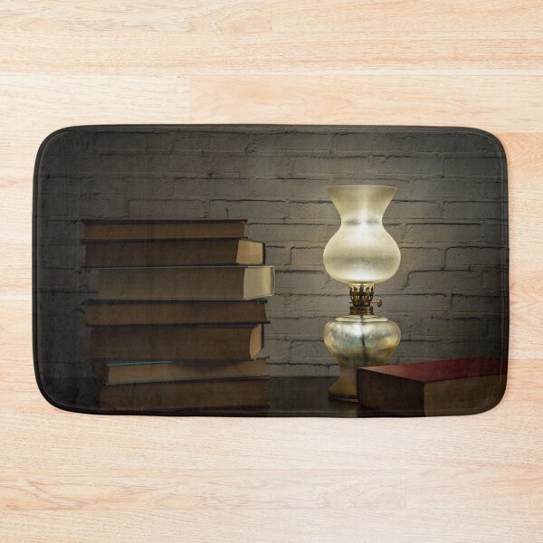 Item preview, The light of an oil lamp illuminates books placed on a dark wooden surface designed and sold by brambillasimone.