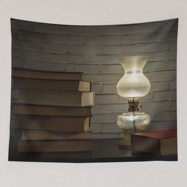 Item preview, The light of an oil lamp illuminates books placed on a dark wooden surface designed and sold by brambillasimone.