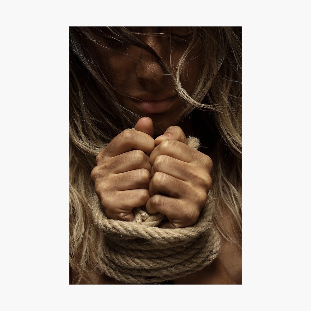 Hands of a girl tied up with a rope