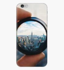 Vinilo o funda para iPhone Hombre sosteniendo una lente sobre Manhattan