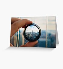 Man holding a lens over Manhattan Greeting Card