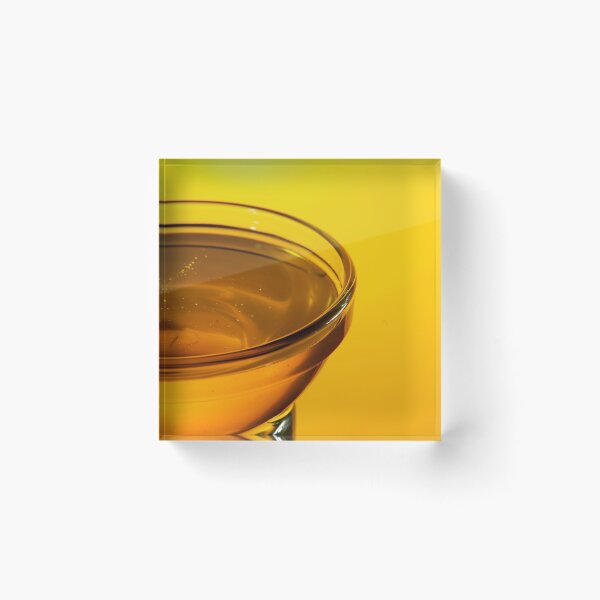 Item preview, Close-up side view of a small glass bowl of honey on a yellow background with backlight designed and sold by vladromensky.