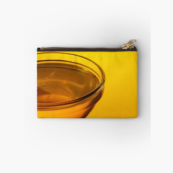 Item preview, Close-up side view of a small glass bowl of honey on a yellow background with backlight designed and sold by vladromensky.