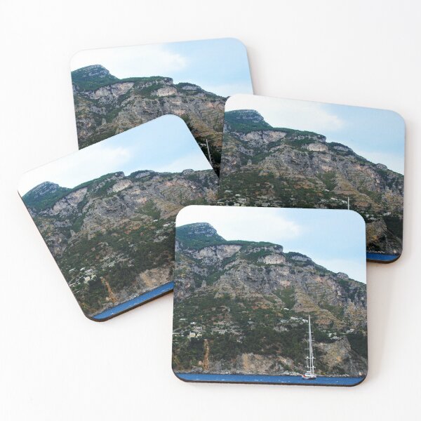 Item preview, View in Amalfi coast at a huge mountain with rocky parts, greenery and buildings with a white boat underneath designed and sold by Kristina Drozd.