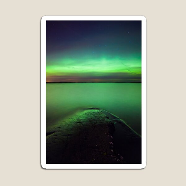 Northern lights glow over lake Magnet