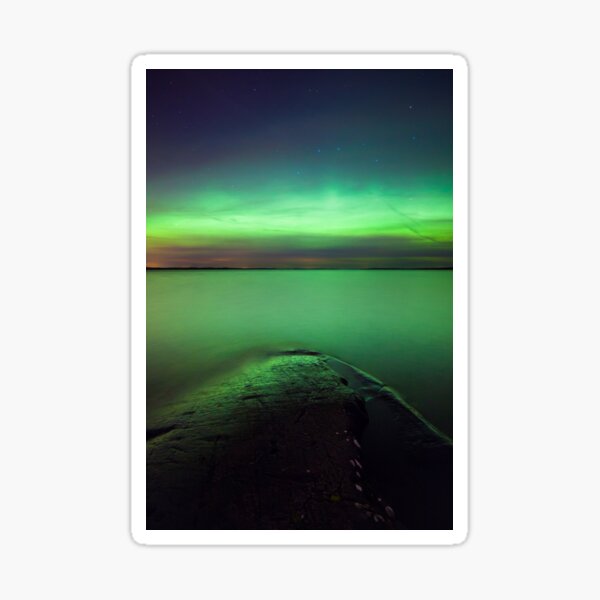 Northern lights glow over lake Sticker