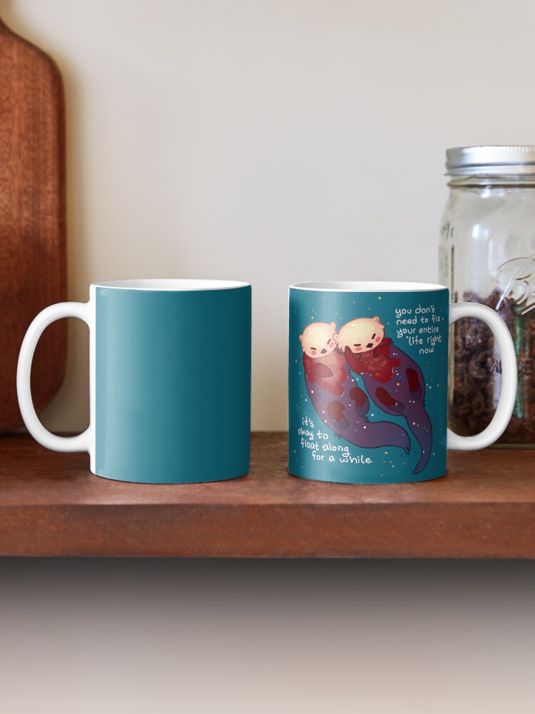Alternate view of "It's Okay to Float Along For a While" Hand Holding Otters Coffee Mug