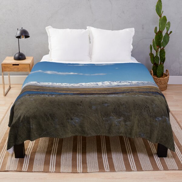 Item preview, Mountain range with snow and blue water, clouds, sky and brown grass designed and sold by Ventures1.