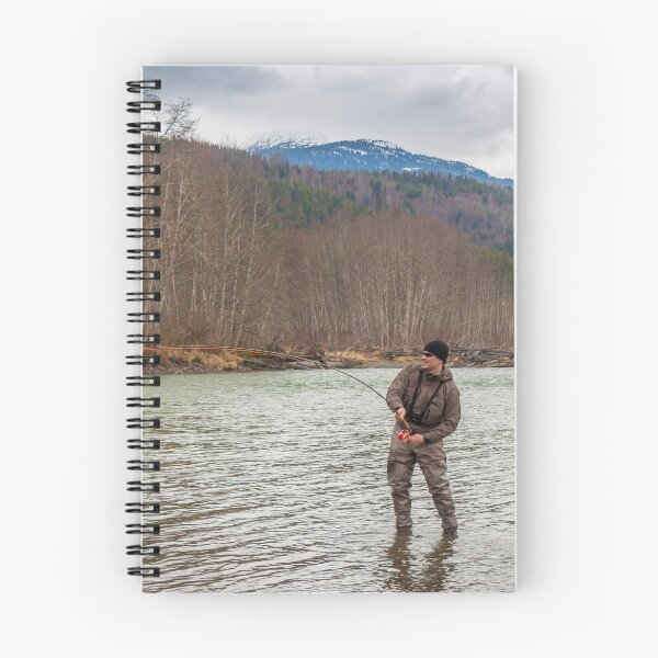 Item preview, A fly fisherman hooked into a big fish in a river with the rod bent designed and sold by SnapTPhotograph.