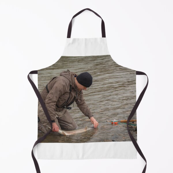 Item preview, An angler unhooking a fly from a steelhead in the morning spring sun designed and sold by SnapTPhotograph.