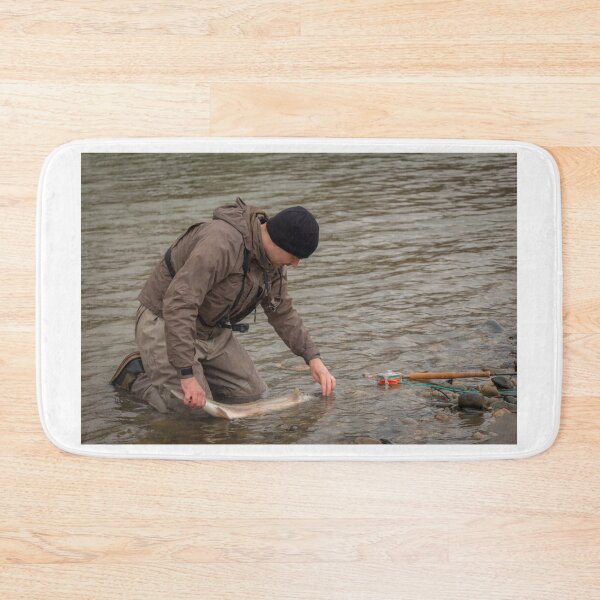 Item preview,  An angler unhooking a fly from a steelhead in the morning spring sun  designed and sold by SnapTPhotograph.