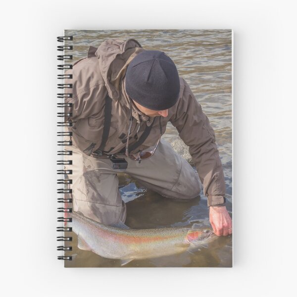 Item preview, An angler unhooking a fly from a steelhead in the morning spring sun designed and sold by SnapTPhotograph.