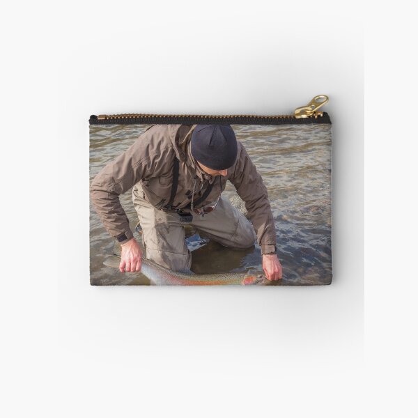 Item preview, An angler unhooking a fly from a steelhead in the morning spring sun designed and sold by SnapTPhotograph.