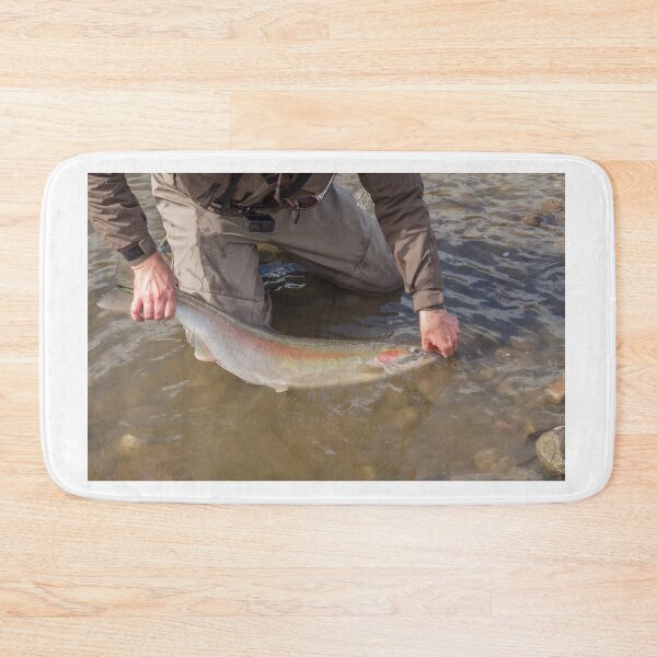 Item preview, An angler unhooking a fly from a steelhead in the morning spring sun designed and sold by SnapTPhotograph.