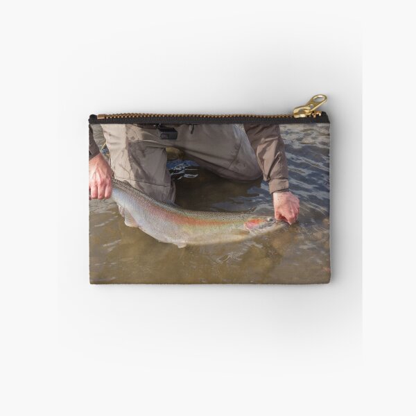 Item preview, An angler unhooking a fly from a steelhead in the morning spring sun designed and sold by SnapTPhotograph.