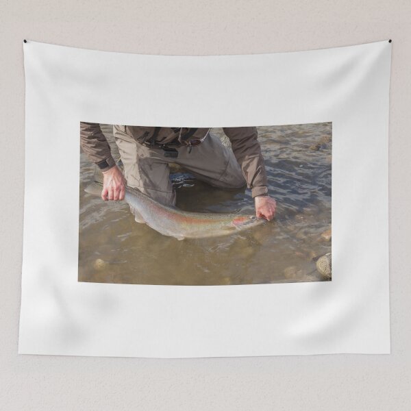 Item preview, An angler unhooking a fly from a steelhead in the morning spring sun designed and sold by SnapTPhotograph.
