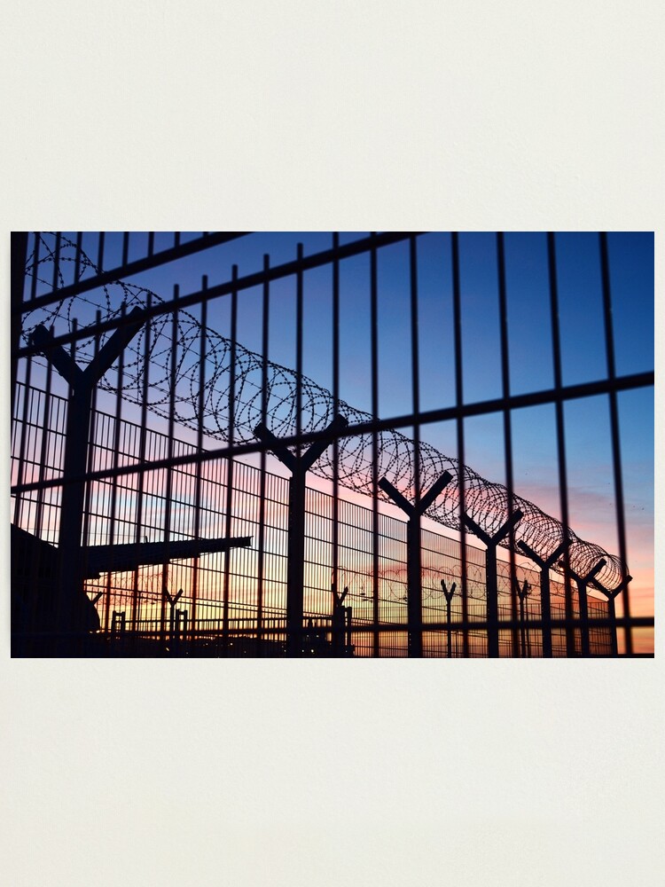 Alternate view of View through a barbed wire fence with beautiful colourful sunset sky in Dieppe France Photographic Print