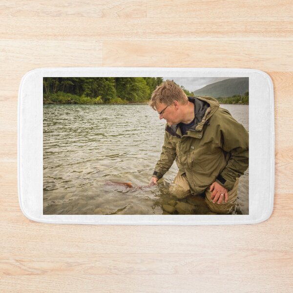 Item preview, A fisherman watches a sockeye salmon swim away, after being released back into the river designed and sold by SnapTPhotograph.