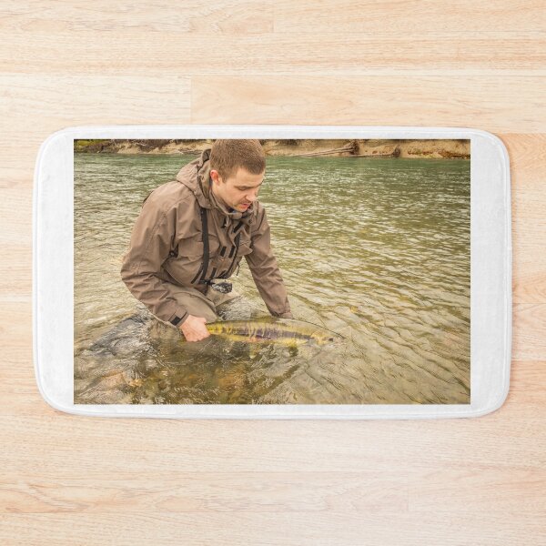 Item preview, A fisherman releasing a chum salmon back into the river, while wading designed and sold by SnapTPhotograph.