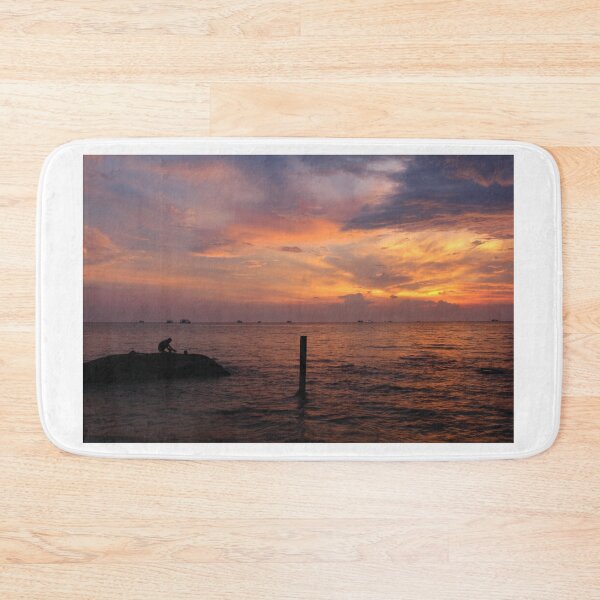 Item preview, A beautiful sunset and silhouette of a person on a rock, at Ba Keo Beach designed and sold by SnapTPhotograph.