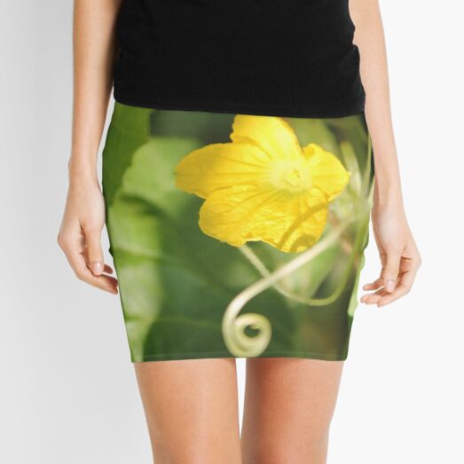 Yellow unnamed flower on a background of green leaves Mini Skirt