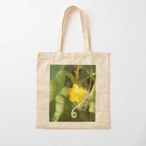 Yellow unnamed flower on a background of green leaves Cotton Tote Bag