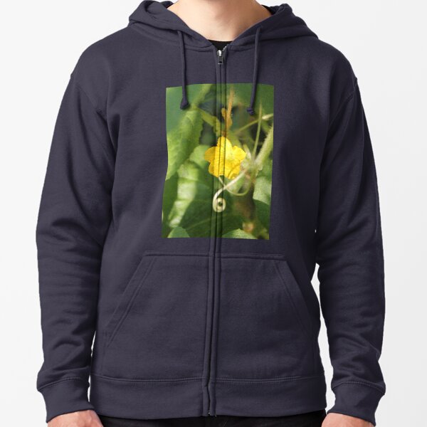 Yellow unnamed flower on a background of green leaves Zipped Hoodie
