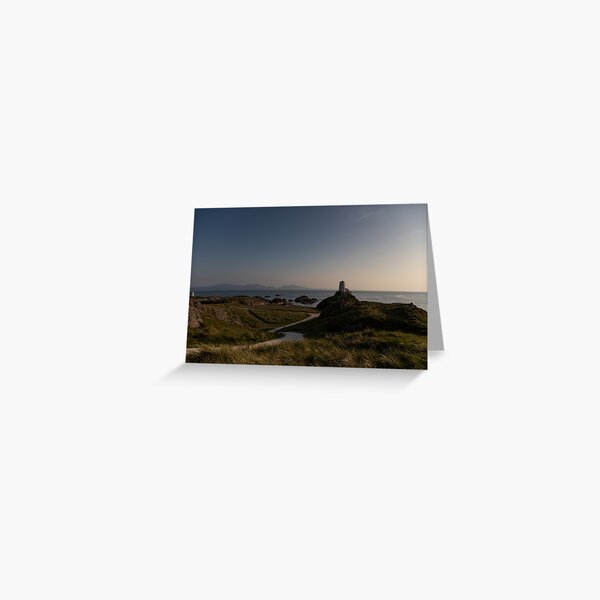 Artikel-Vorschau von Sonnenuntergang über dem Twr Mawr Leuchtturm auf Llanddwyn, Anglesey mit Snowdonia am Horizont, designt und verkauft von donandhiscamera.